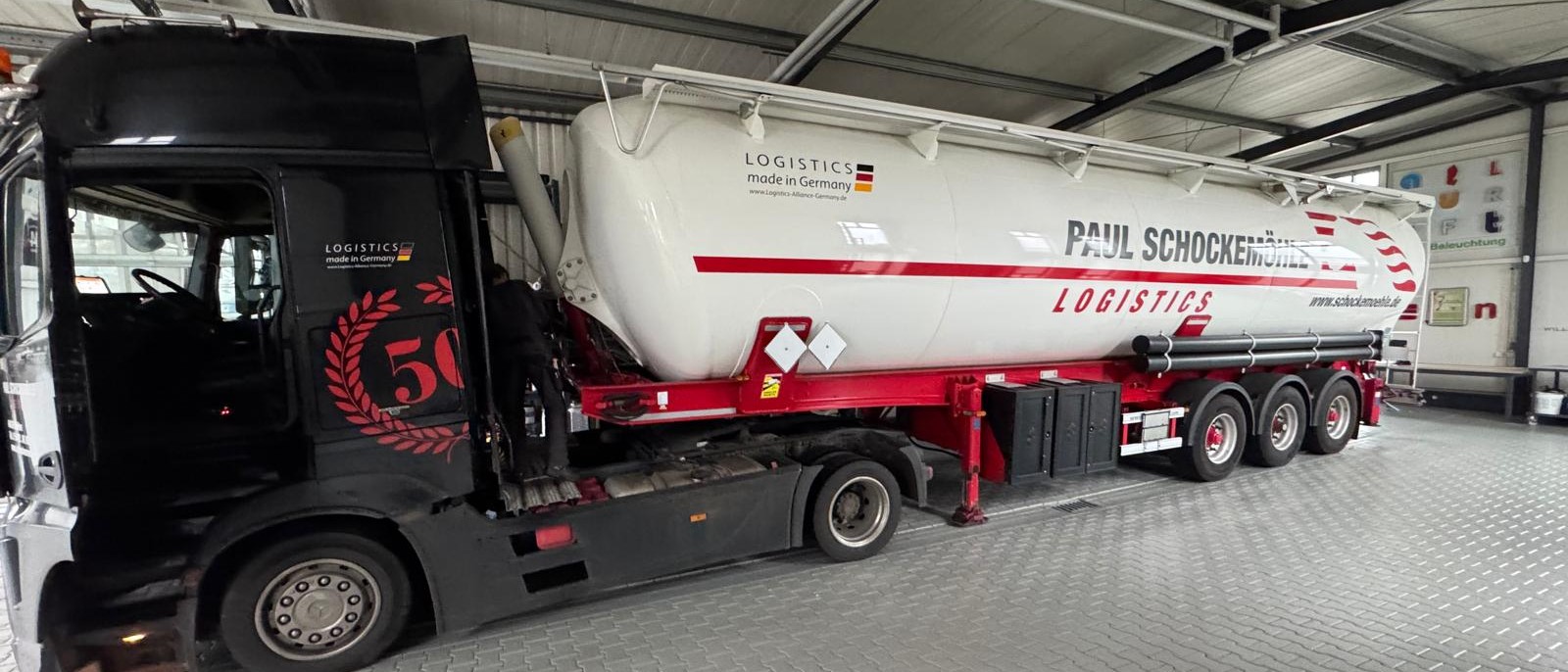 Beschrifteter Silo-Auflieger von Paul Schockemöhle Logistics in der Halle von Willenborg Werbetechnik